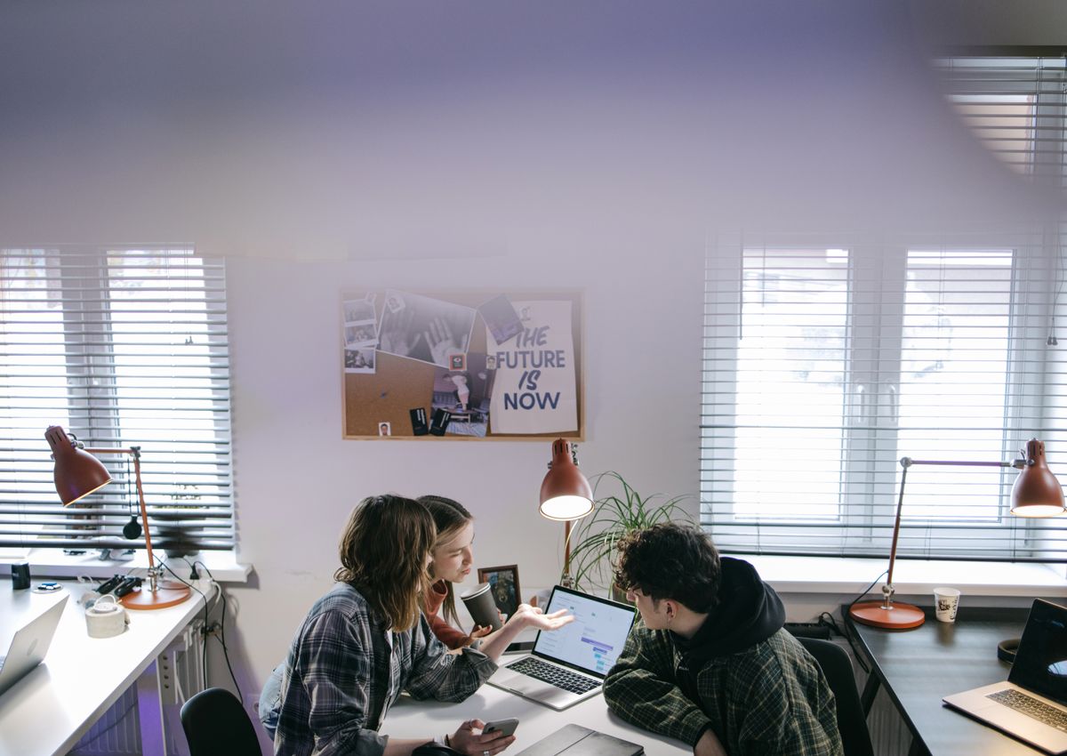 Members of an editorial team reviewing solar research at a table in a bright office