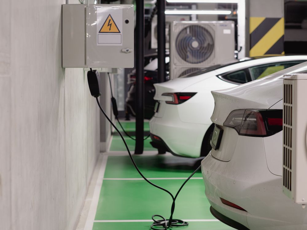 An electric vehicle charging from a home wall charger in a garage