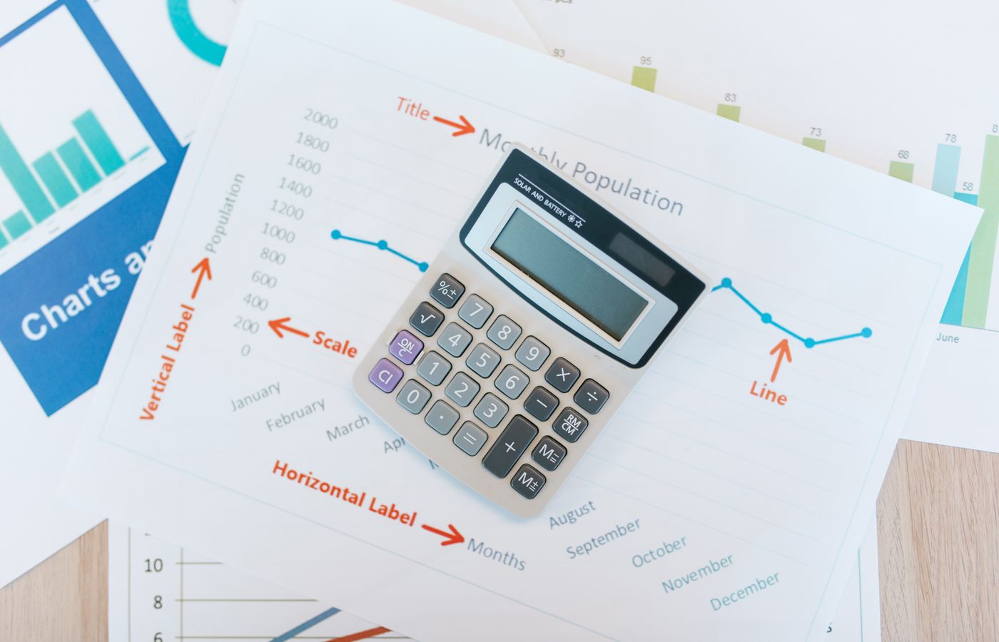 A calculator, notepad, and documents on a kitchen table for planning a solar purchase