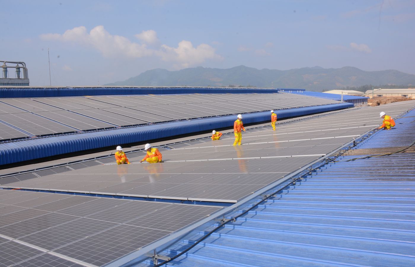 Two installers fastening a solar panel to a residential roof rail