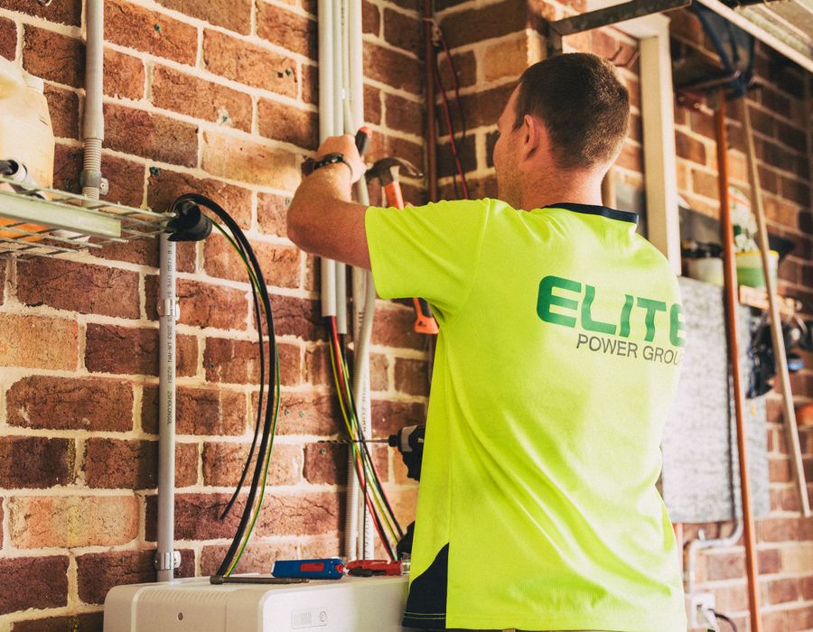 A wall-mounted solar inverter and electrical equipment in a garage